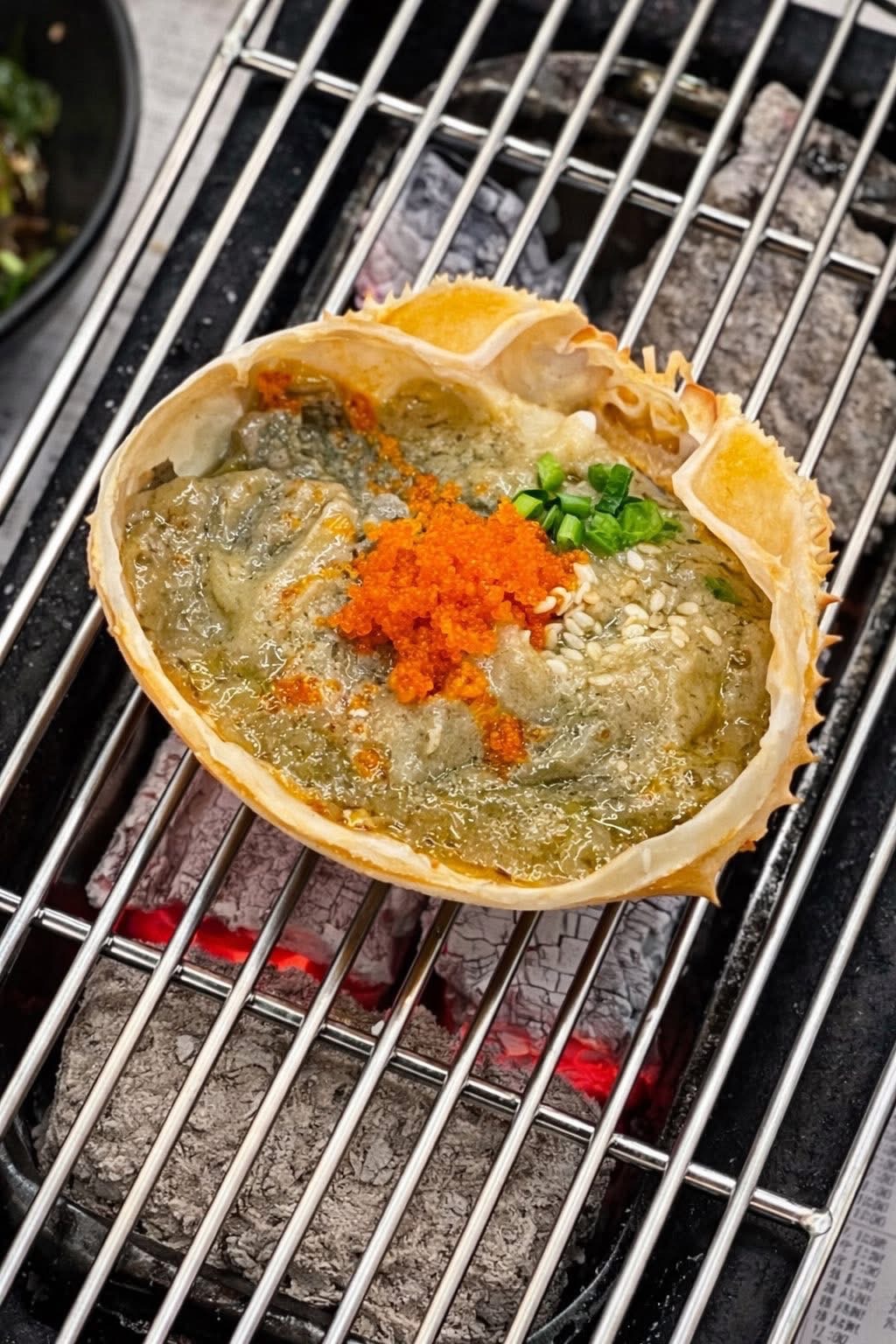Kani miso baked in shell over glowing charcoal
